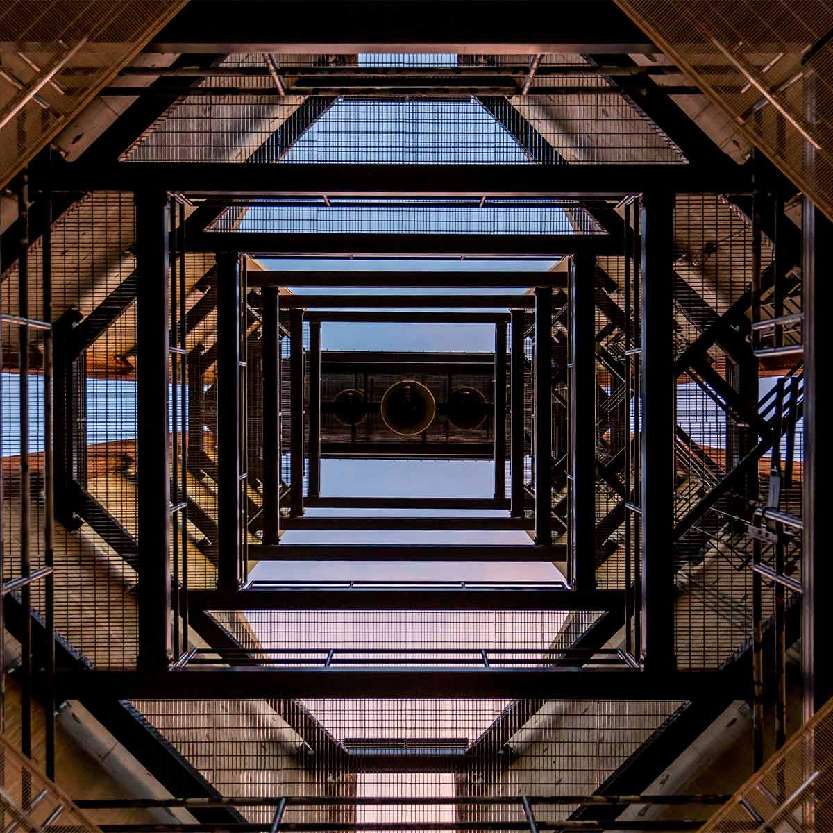 Looking up a scaffolding structure with geometric patterns and reflections