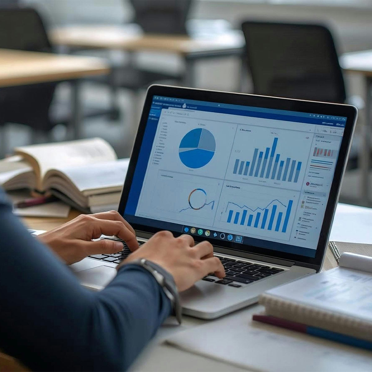 Person using a laptop with data analytics software on a desk in an office setting