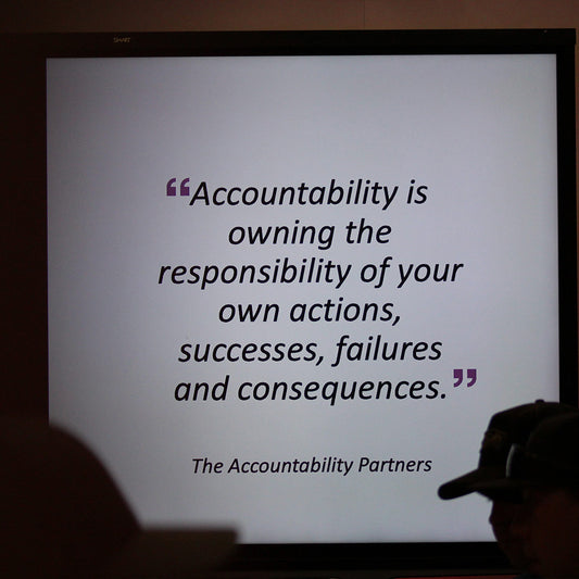 Projection of a screen with a quote that reads "Accountability is owning the responsibility of your own actions, successes, failures and consequences." -The Accountability Partners
