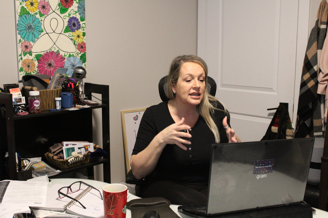 a woman sitting in her office and speaking with a client via video chat