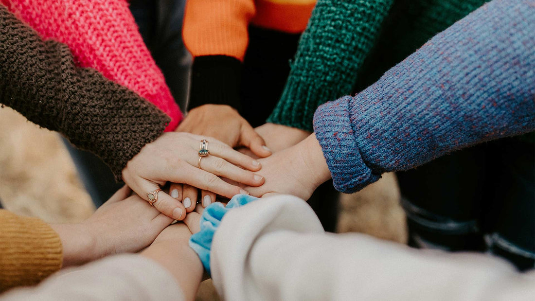 A team of people with their hands in the center