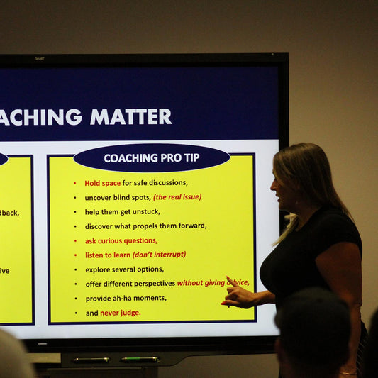 Woman standing in front of a screen behind her that reads "coaching pro tips." with multiple coaching tips beneath it 