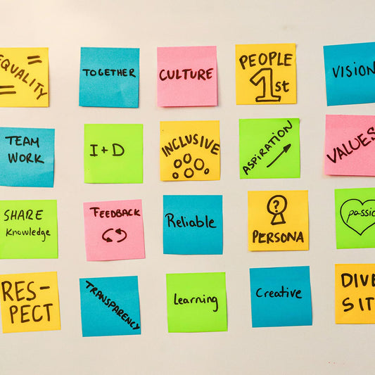 Colorful sticky notes with various core values written on them on a beige background