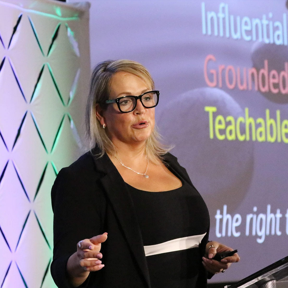 Woman giving a presentation with a screen displaying motivational phrases.