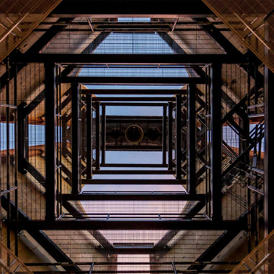 Looking up a scaffolding structure with geometric patterns and reflections